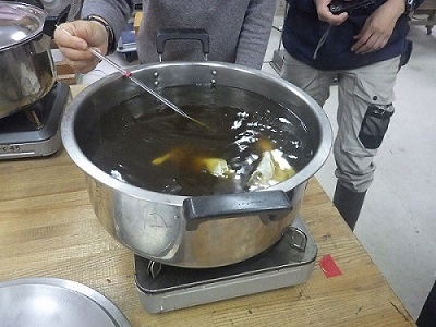 染液に布を投入し加温しながらかきまぜる画像