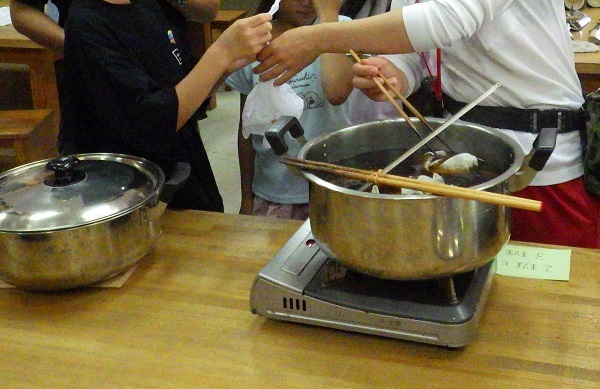 輪ゴムで縛った布を染液に入れる画像