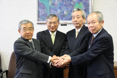 かたい握手を交わす知事