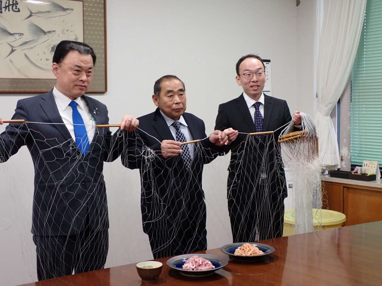 フナを漁獲する刺網を持っての記念撮影