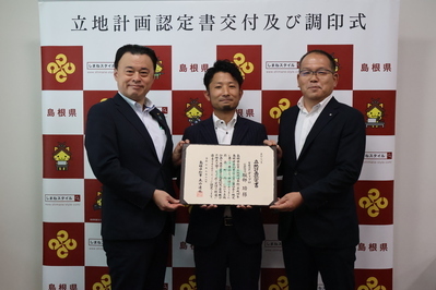 服部功代表取締役（中央）