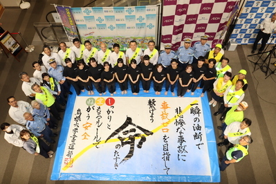 書道パフォーマンスで完成した作品を囲み、参加者の皆さんと記念撮影