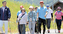 講師を務めたノルディックウオーキングの教室で邑南町民と一緒に歩く荻原健司さん(右から3人目)の写真